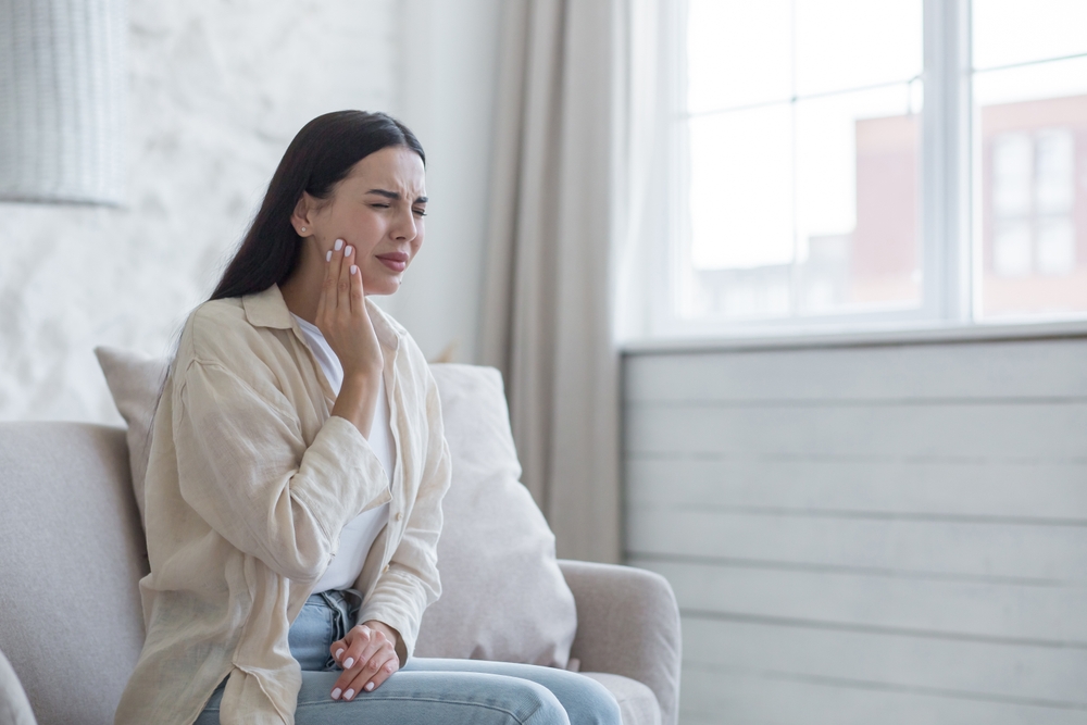 woman alone with a severe, sickness-related toothache